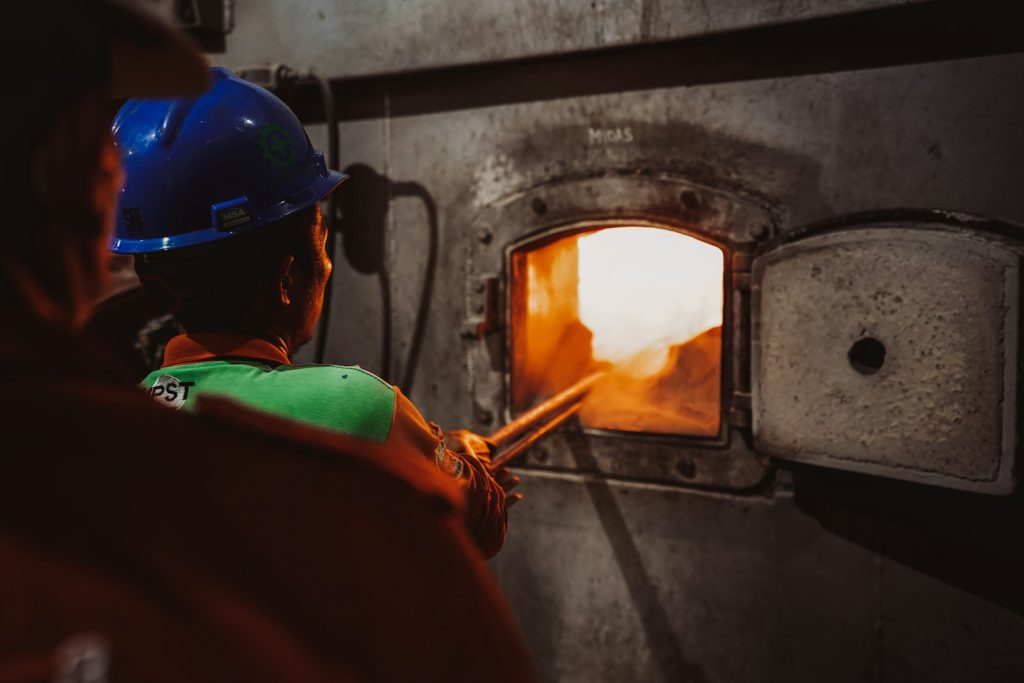 Worker wearing a helmet near an industrial furnace