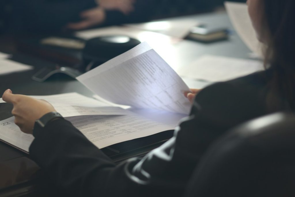 Kantoormedewerker leest document aan tafel