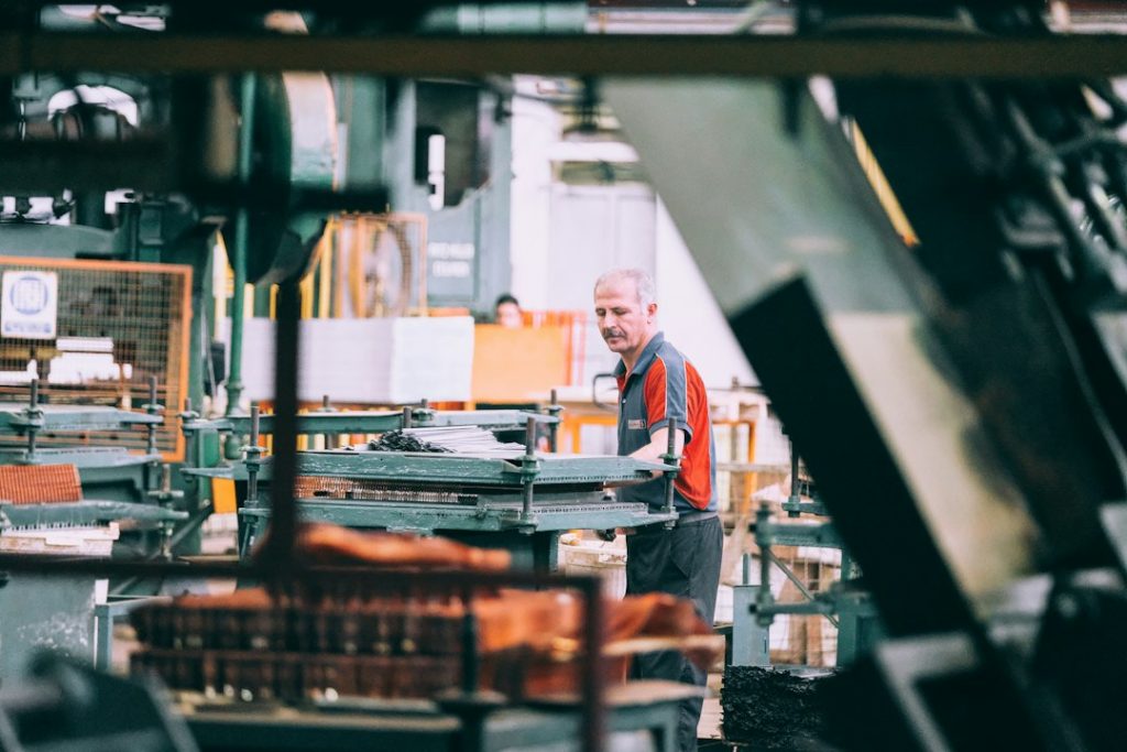 Medewerker bedient industriële machine in fabriek