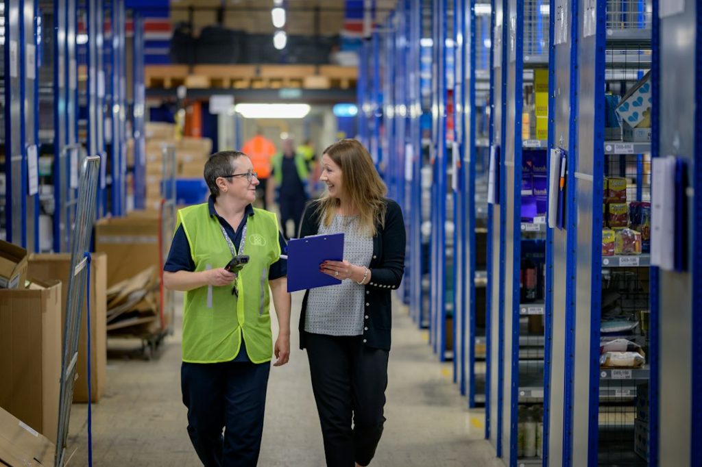 Twee medewerkers lopen door een magazijn