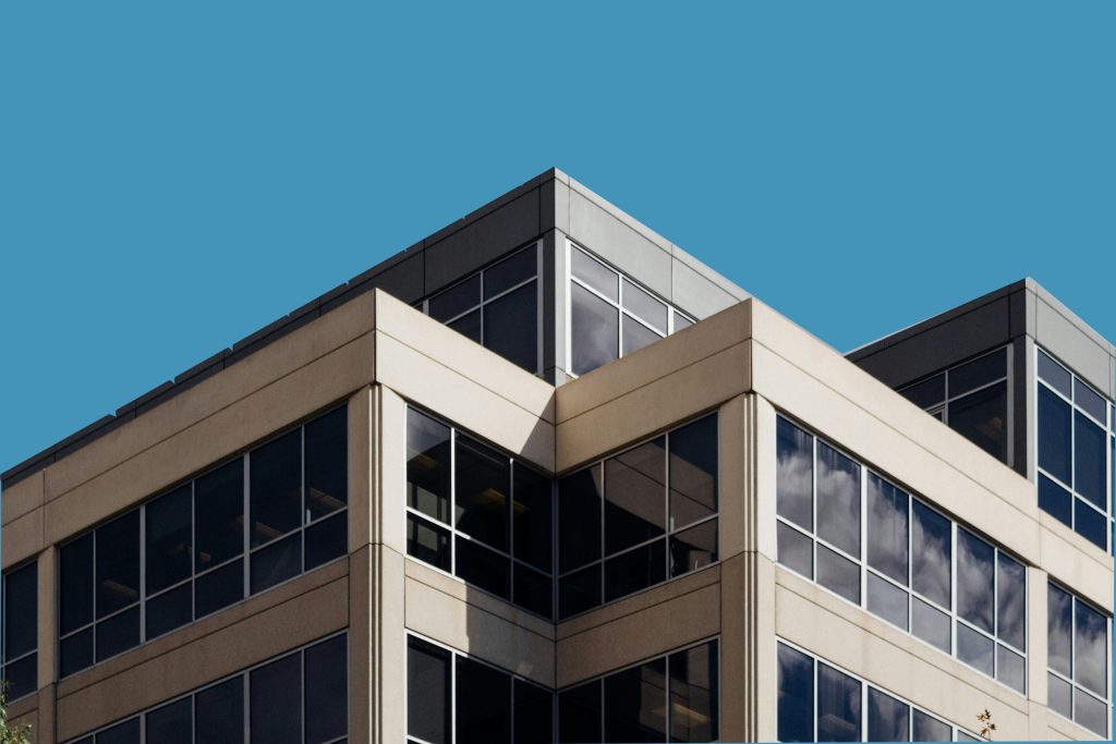 High-rise building with glass facade against blue sky