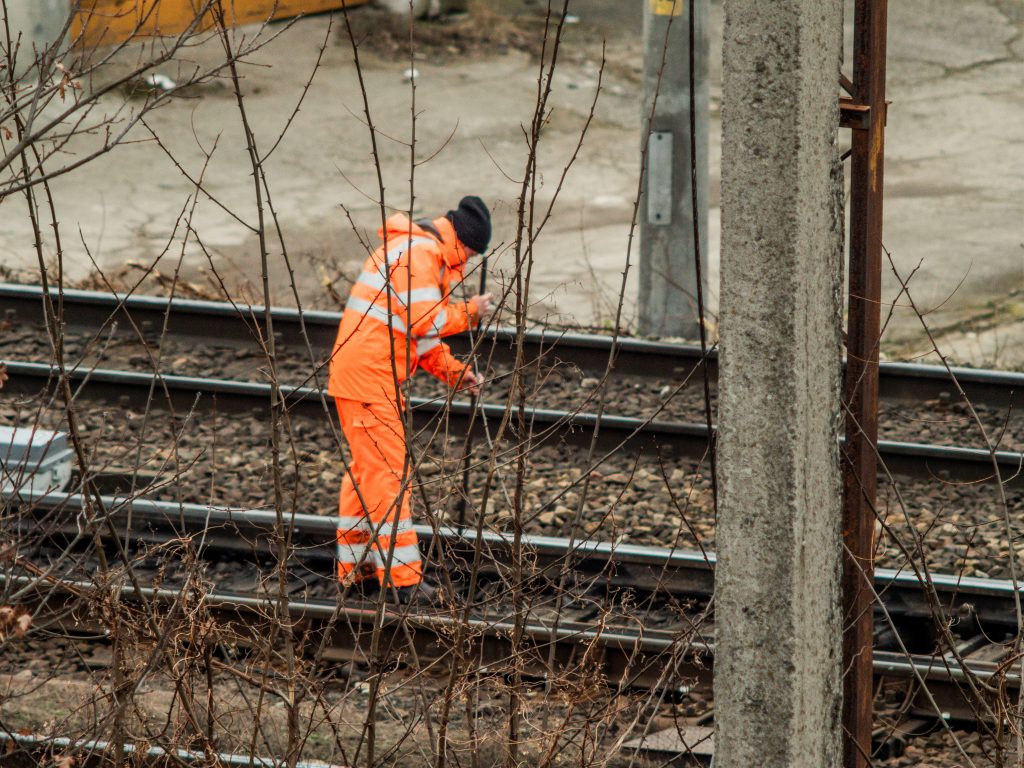 Medewerker in veiligheidskleding werkt aan spoorlijn