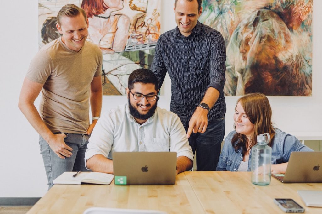 Team werkt lachend samen aan een ontwerp op kantoor