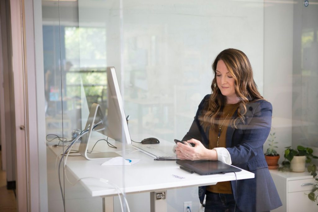 Vrouw werkt aan een sta-bureau op kantoor