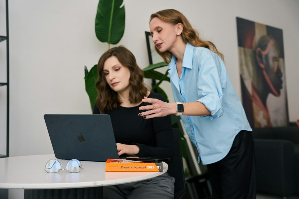 Twee collega's kijken samen naar een laptop