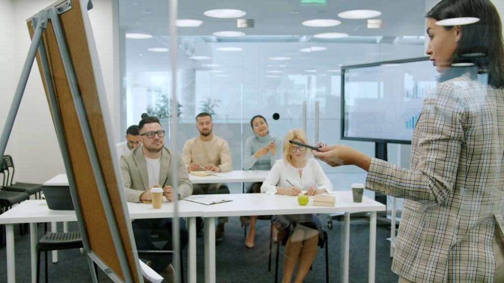Leidinggevenden luisteren naar een jonge medewerker tijdens een training