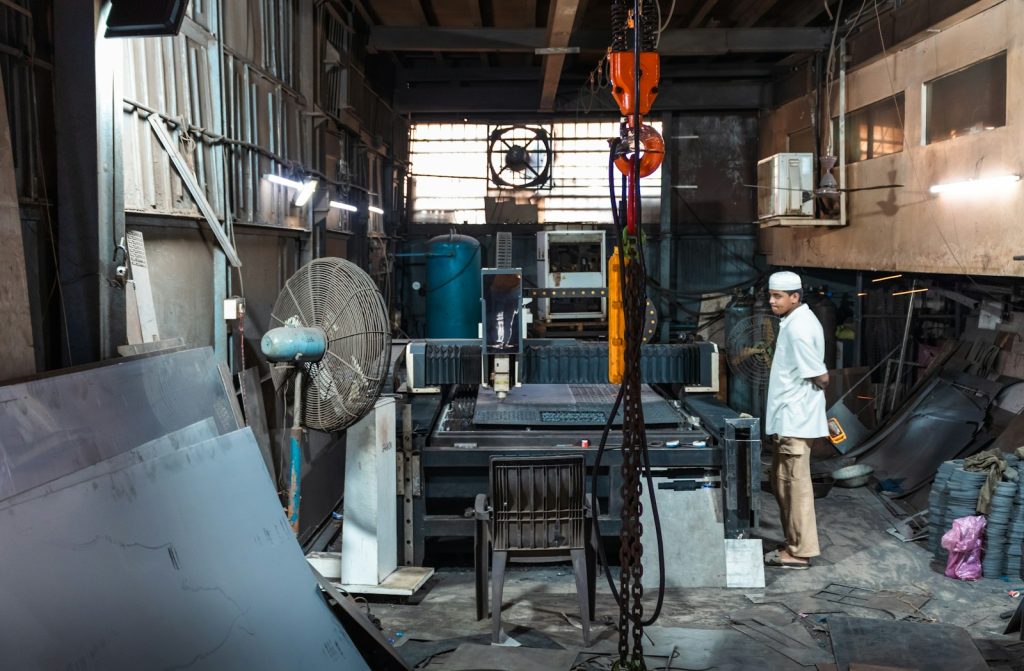 Intérieur d'un petit atelier de métallerie avec une machine de découpe