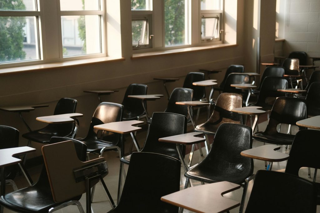 Empty lecture hall with tables and chairs by the window