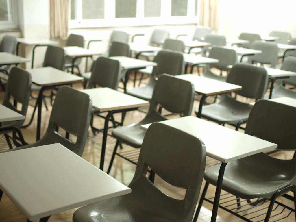 Leerer Hörsaal mit Reihen von Tischen und Stühlen, ohne Kursteilnehmer