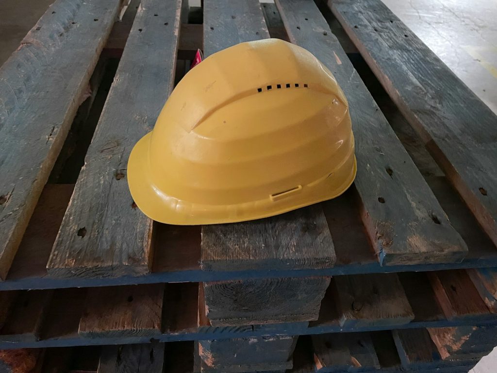 Casque de sécurité jaune posé sur une palette en bois