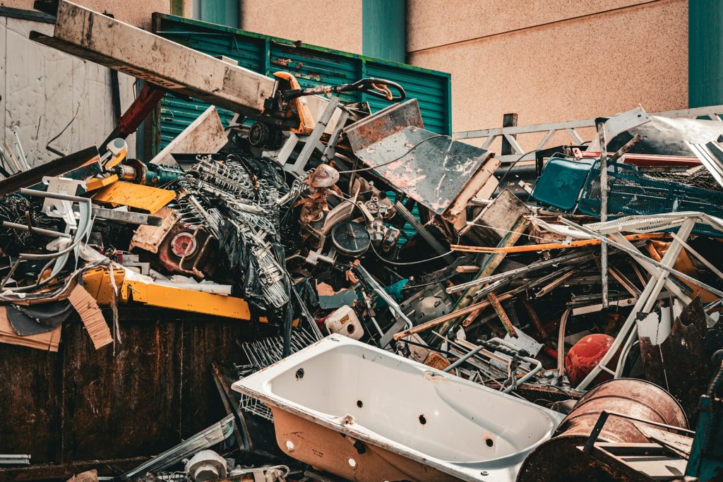 Pile of scrap metal against a wall at a recycling site
