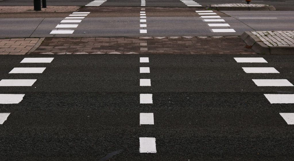 Road with white lane markings at a pedestrian crossing