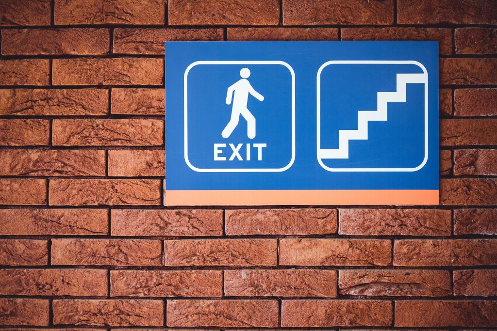 Blue-and-white emergency exit and evacuation route sign on a wall