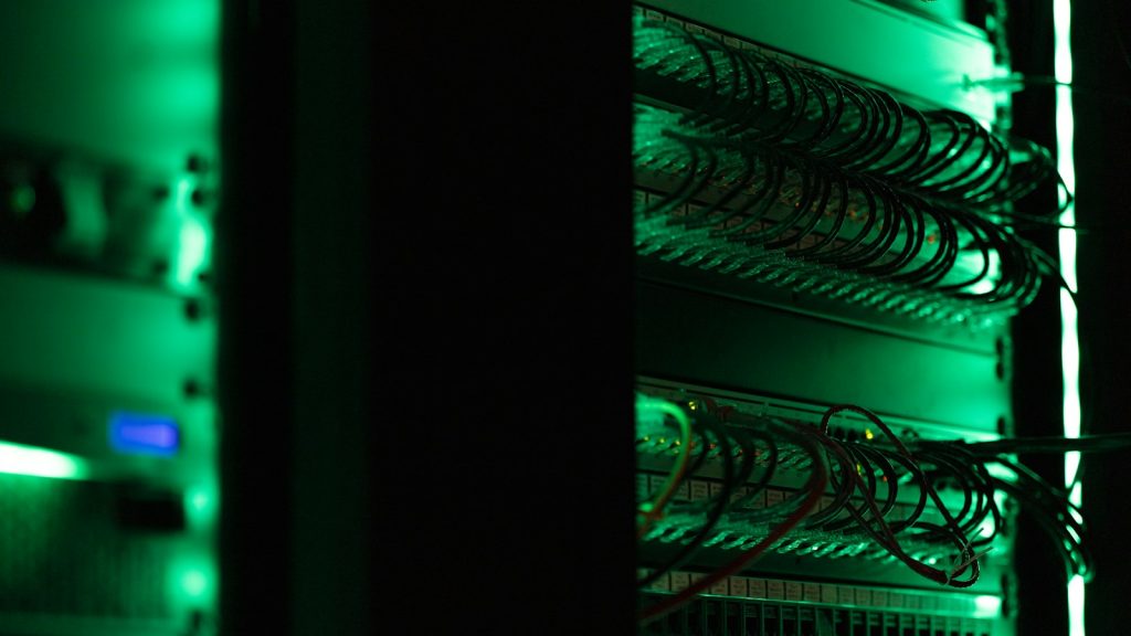 Close-up van een serverrack met groen licht en bekabeling in een datacenter