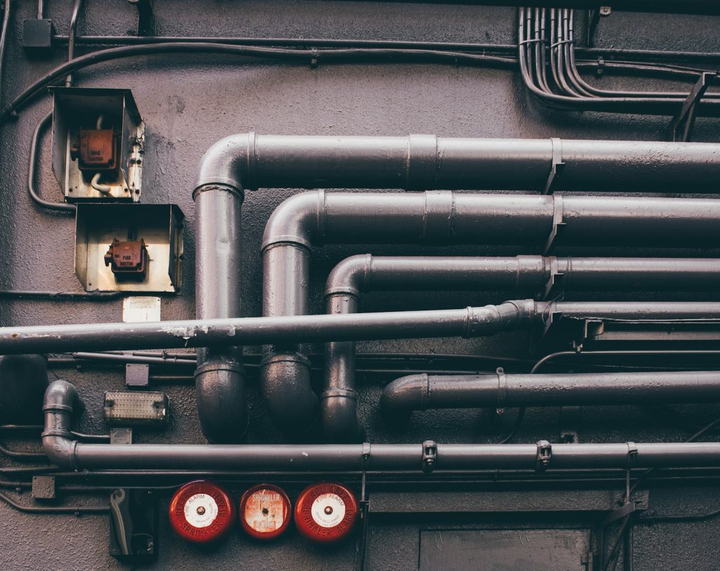 Industrielle Rohrleitungen an einer Wand