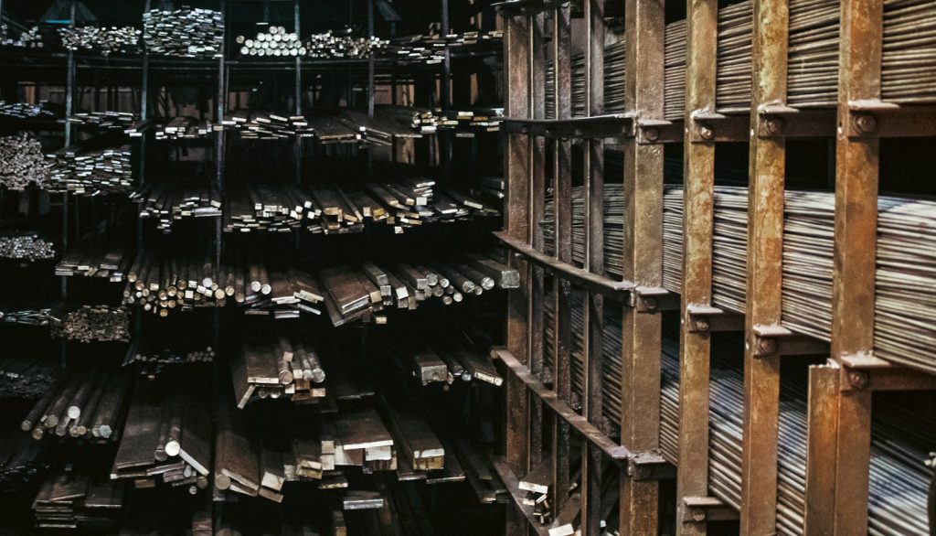 Industrial production hall with a forklift truck and steel components on a loading dock, no people recognisable