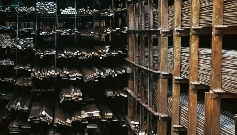 Industriehalle mit einem Gabelstapler und Stahlteilen auf einer Laderampe, keine Personen erkennbar