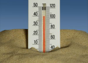 Thermometer in bright sunlight against a clear sky