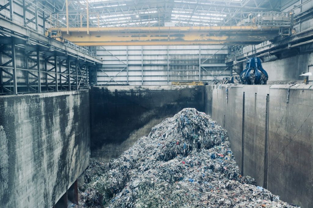Des ouvriers trient des déchets d'emballage sur un tapis roulant dans un hall de tri industriel