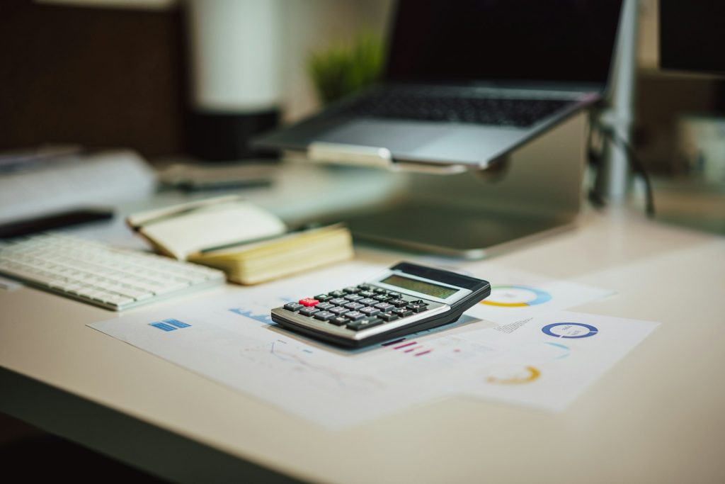 Gros plan sur une calculatrice posée sur un bureau, symbole du calcul des coûts économiques
