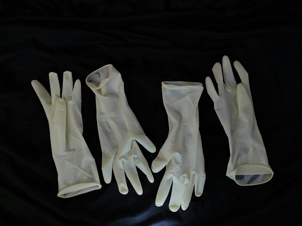 Doorzichtige beschermende handschoenen op een donkere ondergrond