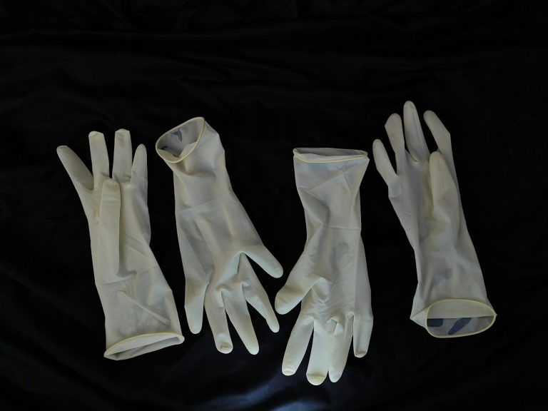 Transparent protective gloves on a dark surface