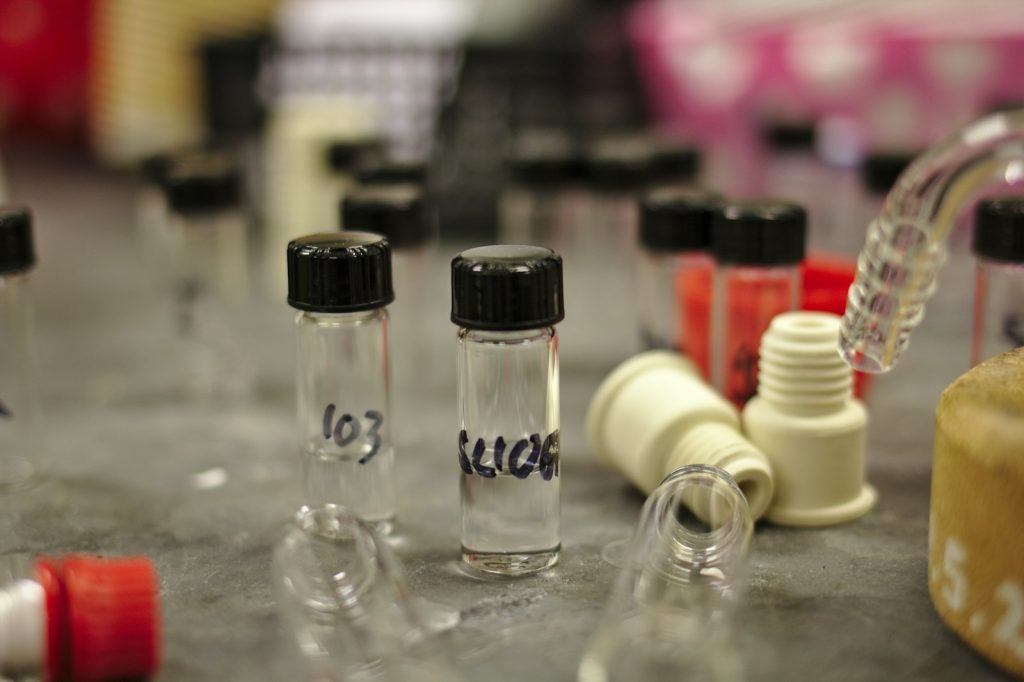 Clear glass bottles of chemical substances in an industrial storage room