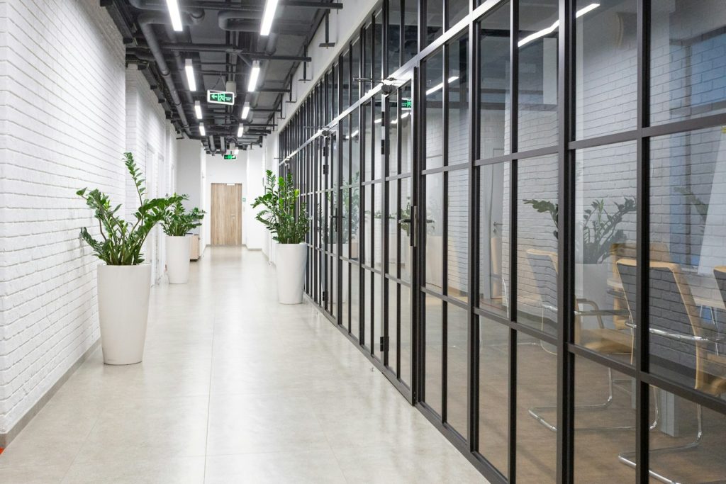 Empty office corridor with glass walls and a smooth floor