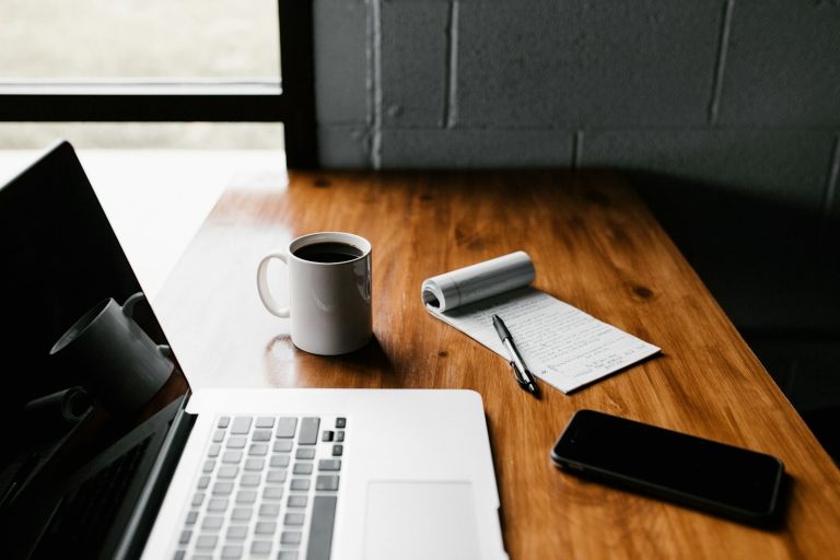 A cup of coffee on a quiet office desk, symbolising workload and stress in the workplace