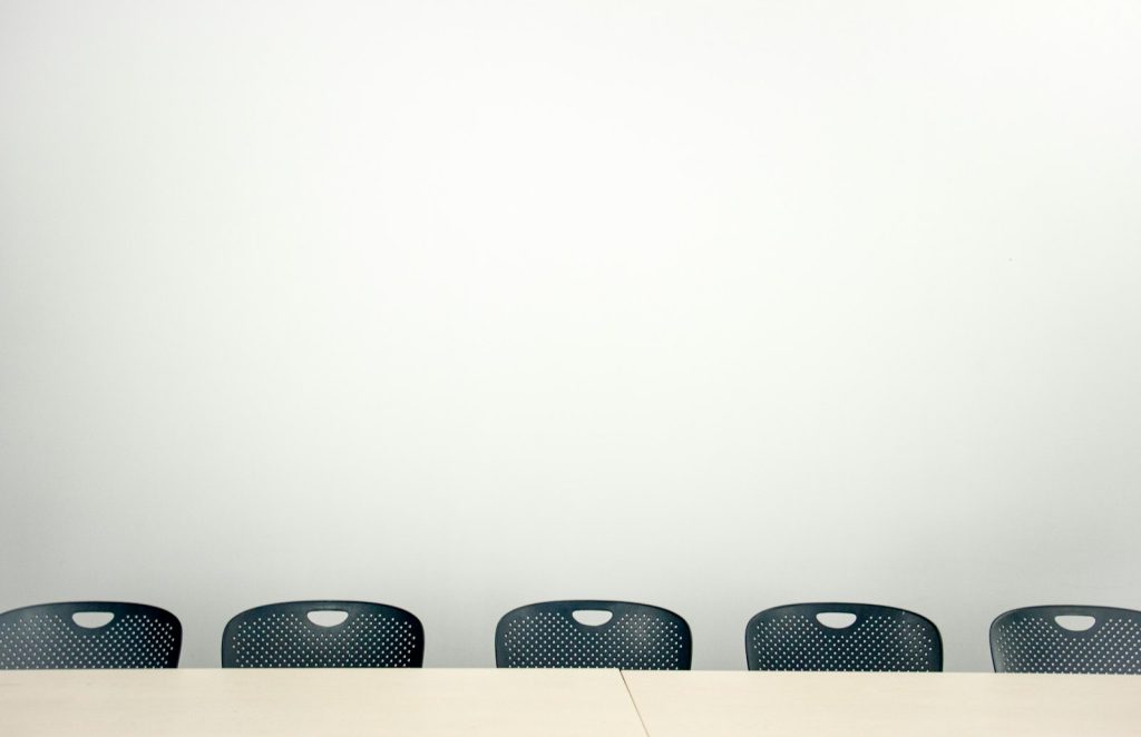 Group of colleagues in discussion at a table in an office, symbolizing collaboration on a healthy psychosocial work environment
