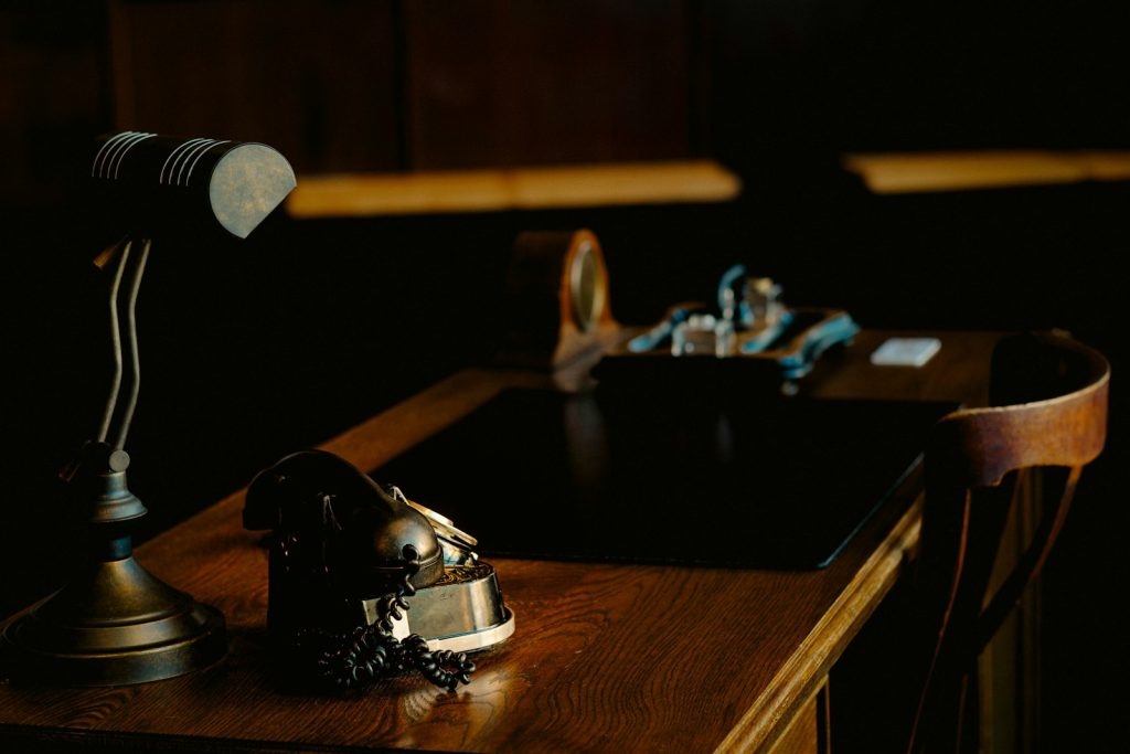 Antique wooden desk with an old telephone and desk lamp