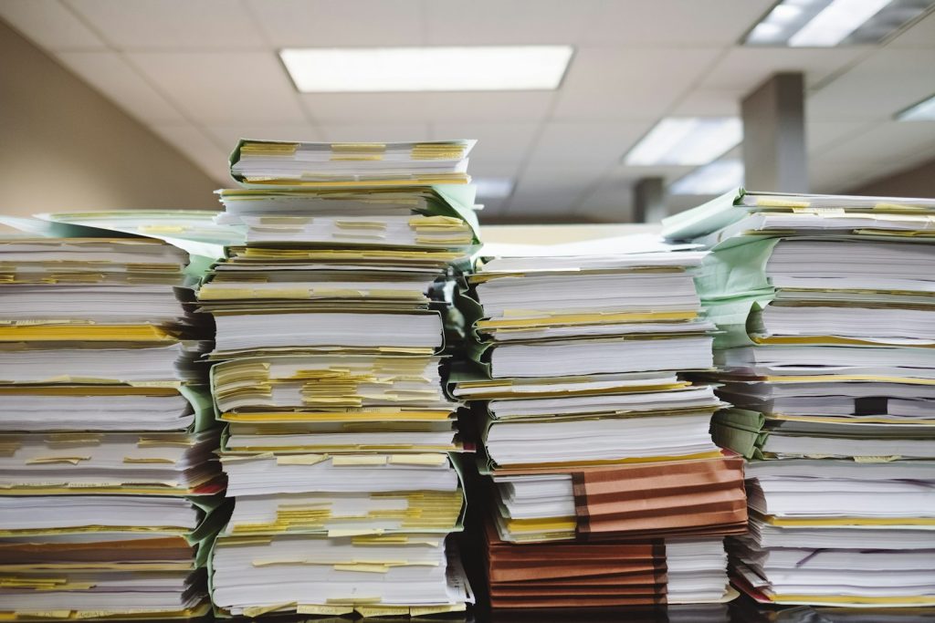 Piles de documents papier et de dossiers sur un bureau